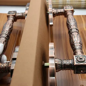Detailed close-up of antique bronze door handle with baroque floral carvings on wood