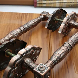 Detail of antique bronze door handles with intricate European floral relief on wood door
