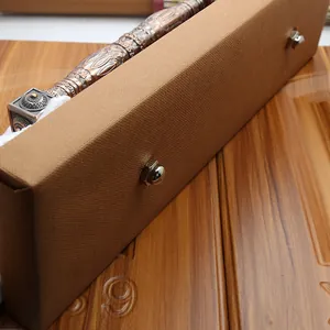 Detailed relief carving on bronze door handle inside a luxury brown gift box