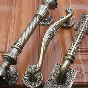 European vintage bronze door handles with antique carvings on a dark wood door
