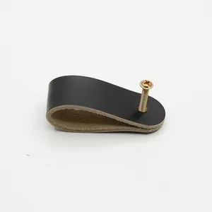 Detail shot of black leather drawer pull with polished gold screw for modern cabinets