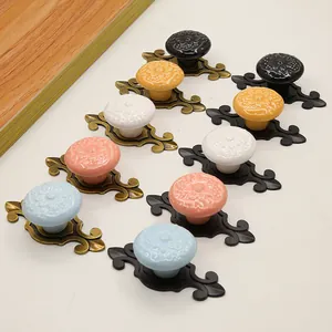 Detail view of colorful ceramic drawer knobs with vintage zinc alloy bases for cabinets