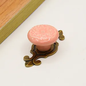 Detail of pink ceramic knob with floral carving and vintage bronze zinc alloy base