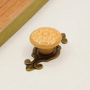Detail of vintage ceramic drawer knob with floral relief and antique bronze zinc base