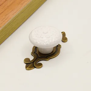 Detail of vintage white ceramic knob with floral carving and antique bronze metal base