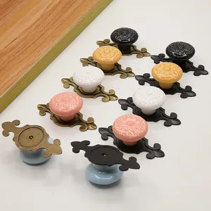 Detail of vintage ceramic drawer knobs with floral patterns and ornate metal bases