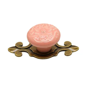 Detail view of pink ceramic flower cabinet knob with retro bronze zinc alloy base