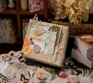 Detail view of vintage floral scrapbooking stickers on a kraft paper gift box