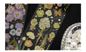 Makro-Detail von PET-Blumenaufklebern mit Vintage Goldfolien-Schmetterling-Designs