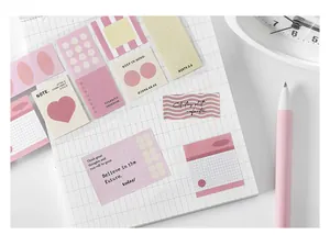 Pegatinas rosas para scrapbooking con patrones geométricos y frases en un cuaderno