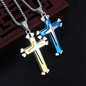 Dettaglio di collane a croce geometriche con accenti blu e oro su una catena a scatola