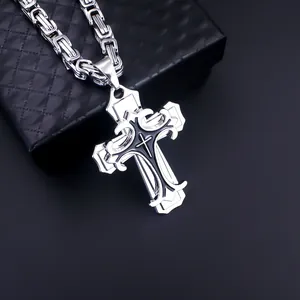Detailed macro view of a men's double-layered cross pendant with a black Byzantine chain