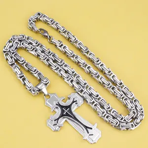 Macro detail of silver stainless steel Byzantine chain and black layered cross pendant