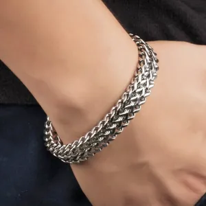 Détail d'un bracelet gourmette tressé lourd en acier inoxydable sur poignet masculin