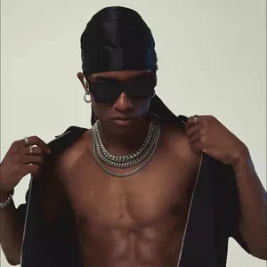 Detail of layered silver Cuban link chains on male model with street style accessories
