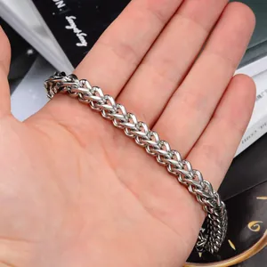 Gros plan détaillé d'un bracelet pour hommes en acier inoxydable tressé argenté