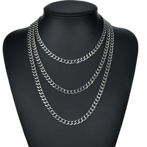 Detailed view of triple-layered silver Cuban link necklaces on a black neck mannequin