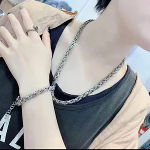 Detail einer massiven Edelstahl-Kette und eines passenden Armbands an einem männlichen Model