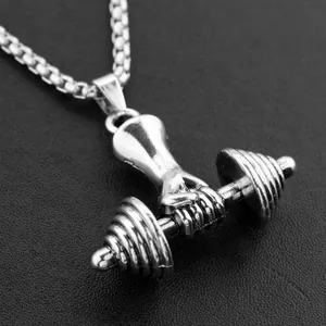 Close-up of silver dumbbell pendant with hand grip detail on black textured surface