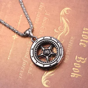 Gros plan du pendentif en acier titane en forme de pneu avec rayons étoilés sur carnet