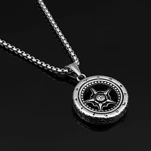 Macro d'un pendentif pneu en acier inoxydable argenté avec étoile sur miroir noir