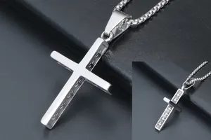 Macro shot of silver cross pendant with intricate engraved cross details on box chain