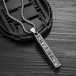 Vintage Sanskrit mantra pendant necklace in polished silver on dark wood table