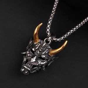 Detalle del colgante de máscara Oni en acero de titanio con cuernos dorados y plata antigua