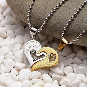 Detail of couple's heart puzzle necklaces with crystal accents and I Love You engraving