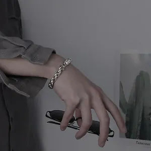 Dettaglio di un bracciale a catena cubana d'argento al polso con finitura in metallo freddo