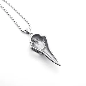 Macro-opname van een vintage zilveren roestvrijstalen adelaarsschedel hanger aan een ketting