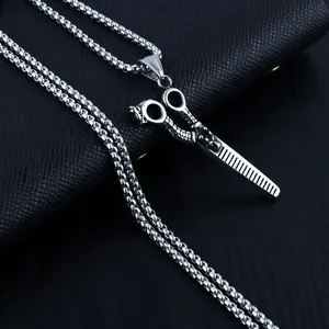 Détail macro du pendentif ciseaux argenté sur fond en cuir noir texturé