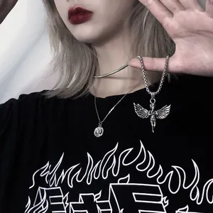 Detalle de dos collares de alas de ángel plateadas de estilo punk vintage en un modelo