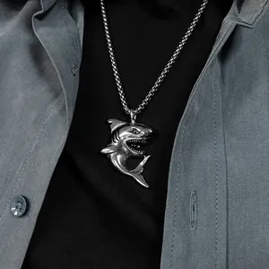 Close-up of a silver shark pendant in stainless steel with a heavy curb chain on model