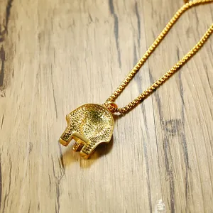 Detailed back view of gold skeleton pendant with intricate grainy metal texture and box chain