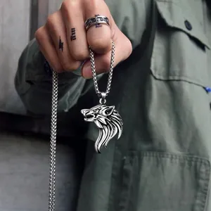 Close-up of a punk-style stainless steel wolf head pendant and carved ring on a model