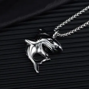 3D shark head pendant necklace in polished stainless steel on a textured black background