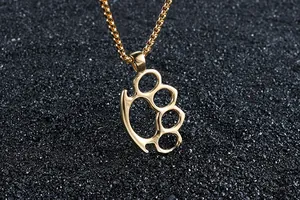 Detailed close-up of golden stainless steel knuckle duster pendant on a box chain