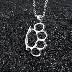 Polished stainless steel brass knuckles pendant necklace on a dark textured background