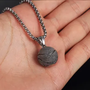Close-up of silver basketball pendant necklace with detailed texture on pearl chain