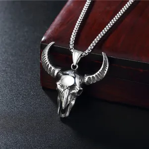 Vintage bull skull pendant necklace in silver stainless steel on a wooden box