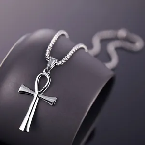 Macro-opname van gepolijste zilveren Ankh-kruis hanger met kralenketting op zwart