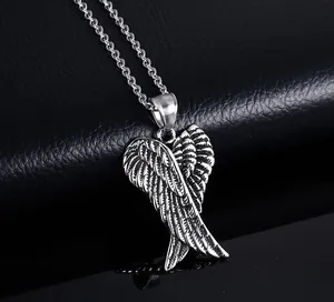 Close-up of vintage silver angel wing pendant with detailed feather texture and cross chain