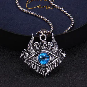 Macro shot of gothic evil eye pendant with three skulls and blue eye on metal chain