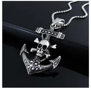 Macro shot of punk style anchor and skull crossbones pendant on polished black leather