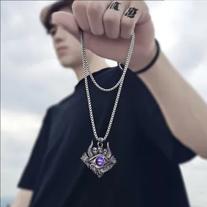 Macro shot of gothic evil eye pendant with three skulls on a steel link chain