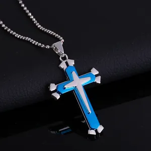 Detalle del colgante de cruz multicapa azul y plateado en cadena de bolas de acero