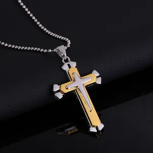 Detalle de colgante de triple cruz en oro y plata con cadena de bolas finas