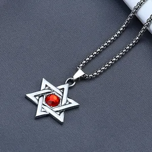 Macro shot of silver hexagram pendant with a faceted red center stone on a link chain