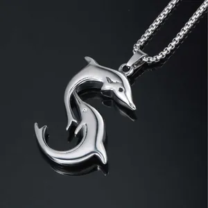 Polished silver dolphin pendant with box chain on a black reflective background